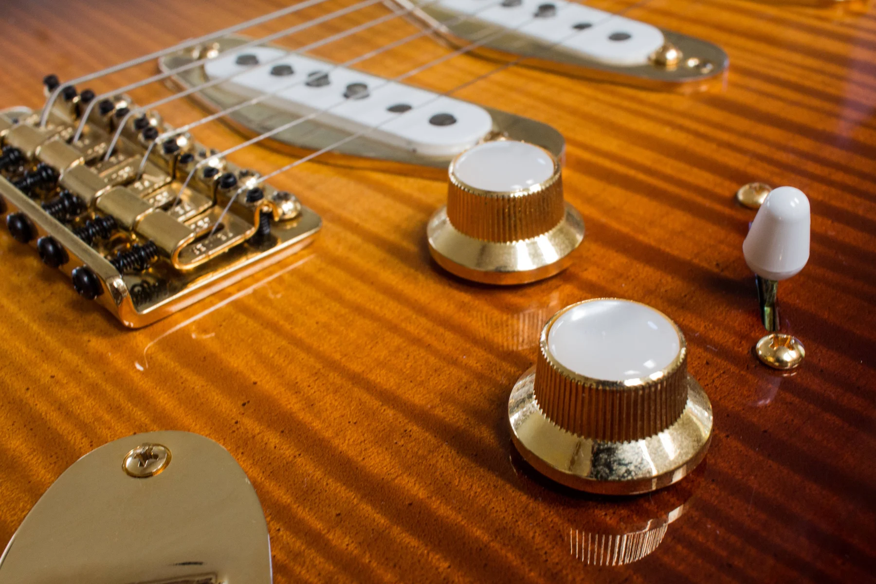 Figured electric guitar body with amber finish and gold hardware