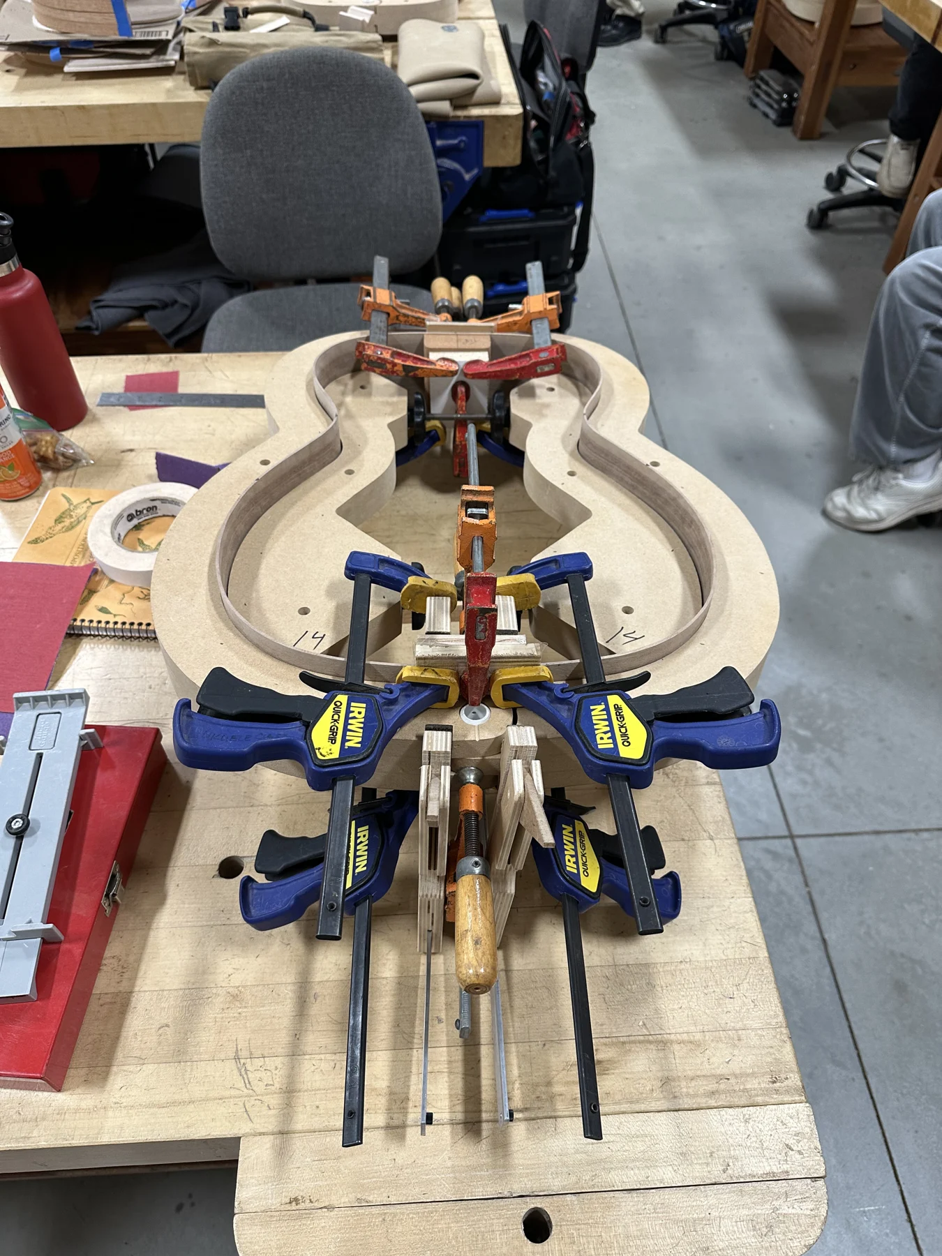 Acoustic guitar under clamps on the workshop bench