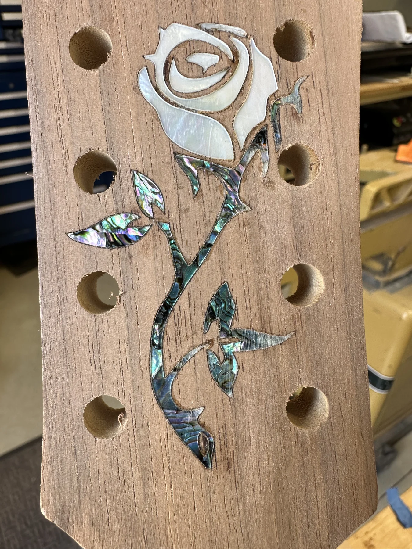 Hand-crafted rose inlay on a wooden instrument headstock